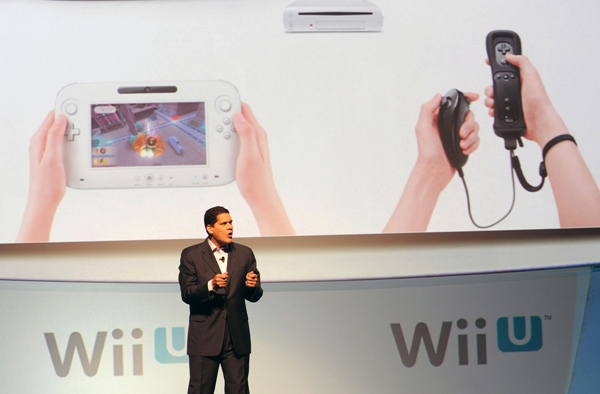 In this photo provided by Nintendo of America, Reggie Fils-Aime, president and coo of Nintendo of America, describes the features of the new Wii U console's controller (left) and the system's (top) compatibility with the current Wii Remote controller during the company's presentation on the opening day of the 2011 Electronic Entertainment Expo (E3), June 7, 2011 in Los Angeles. The E3 is the video game industry's premier trade show. (Photo by Nintendo of America, Bob Riha, Jr.) No Sales